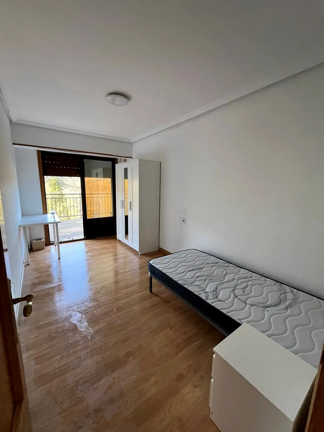 Habitación reformada con escritorio y salida al balcón