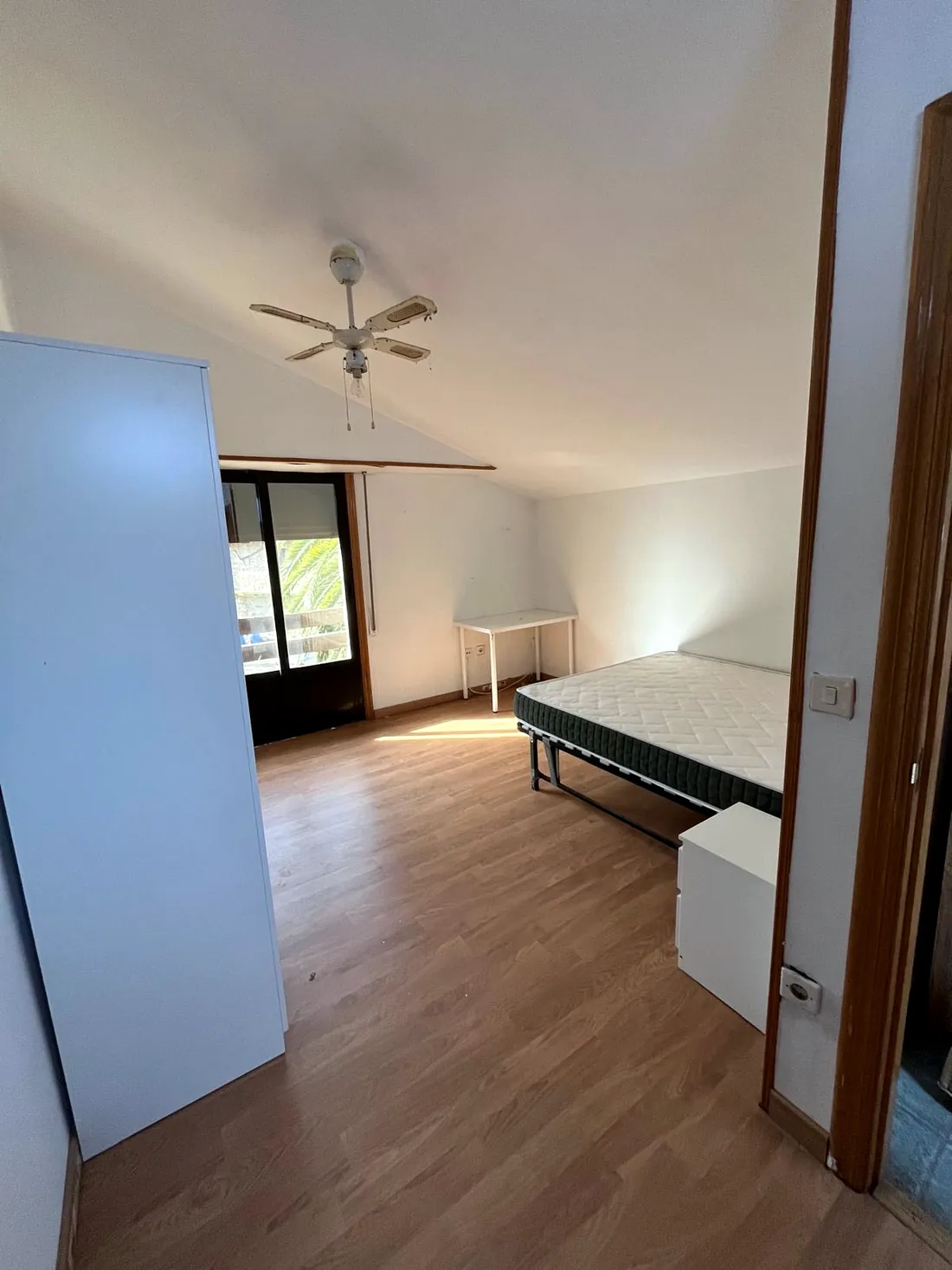Habitación amplia con ventilador de techo y salida a terraza